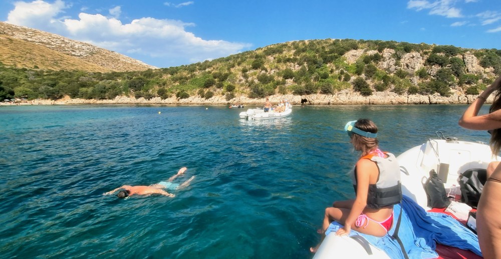 Boat tour near Cala Moresca with turquoise waters