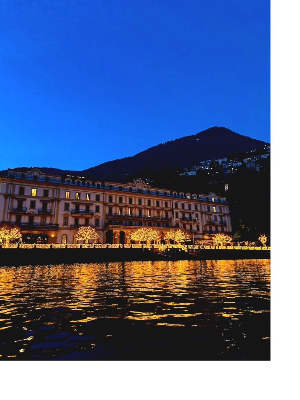 Illuminated lakeside villa seen during a Lake Como evening boat tour